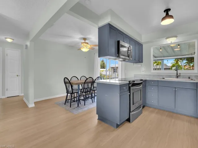 Kitchen featuring appliances with stainless steel finishes, a sink, light wood-style floors, and healthy amount of natural light