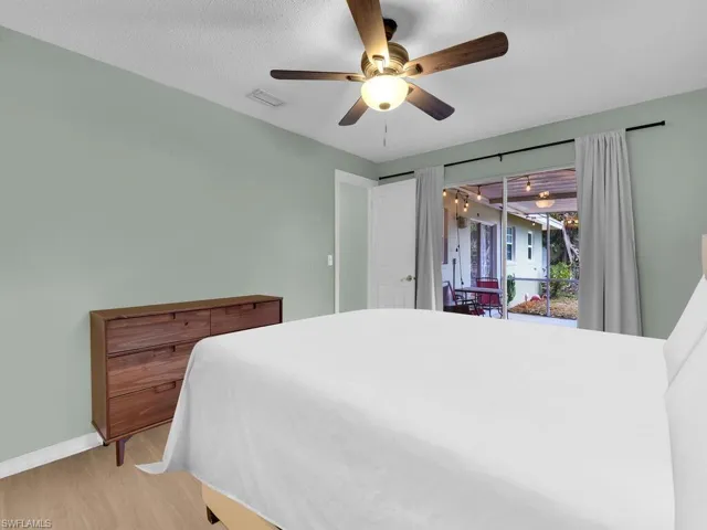 Bedroom with wood finished floors, a ceiling fan, and baseboards