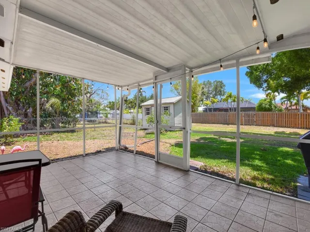 Unfurnished sunroom featuring lofted ceiling, healthy amount of natural light, and a residential view
