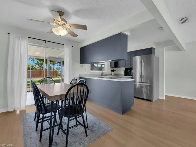 Dining space with healthy amount of natural light, ceiling fan, light wood-style flooring, and a textured ceiling