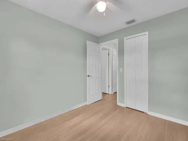 Unfurnished bedroom with light wood-type flooring, baseboards, a closet, ceiling fan, and a textured ceiling