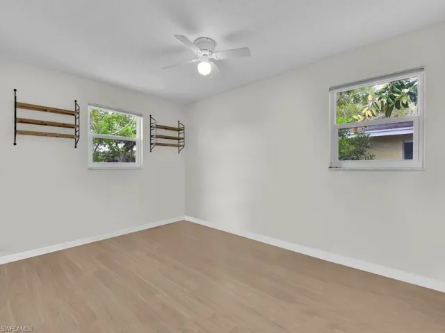 Spare room with healthy amount of natural light, wood finished floors, and baseboards