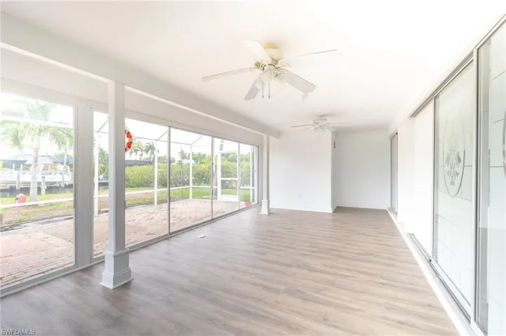 Unfurnished sunroom featuring ceiling fan