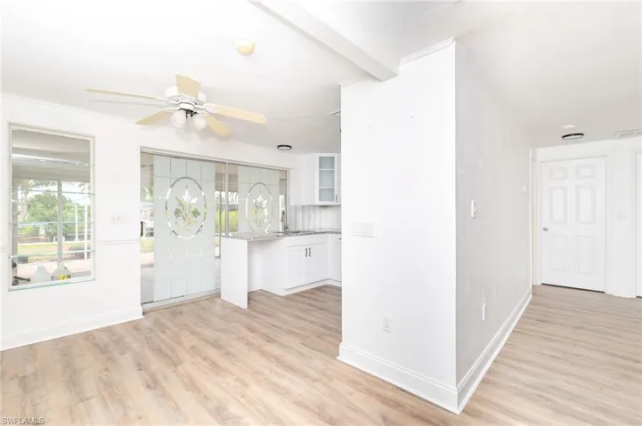 Foyer entrance with beamed ceiling, ceiling fan, and light hardwood / wood-style floors