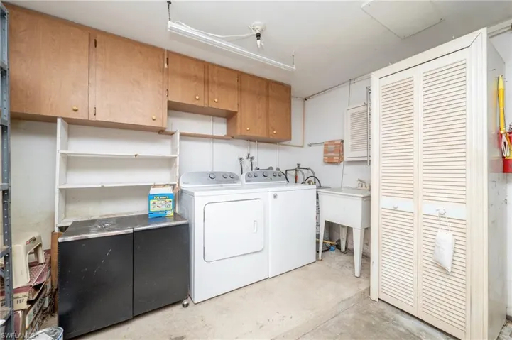 Washroom featuring cabinets, washing machine and dryer, and hookup for a washing machine