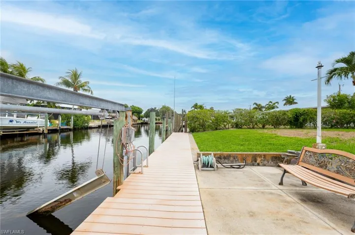 View of dock with a water view and a yard