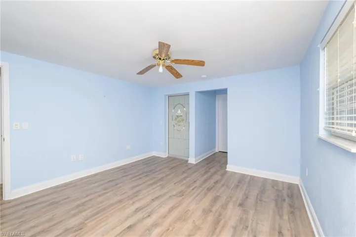 Empty room with ceiling fan and hardwood / wood-style flooring