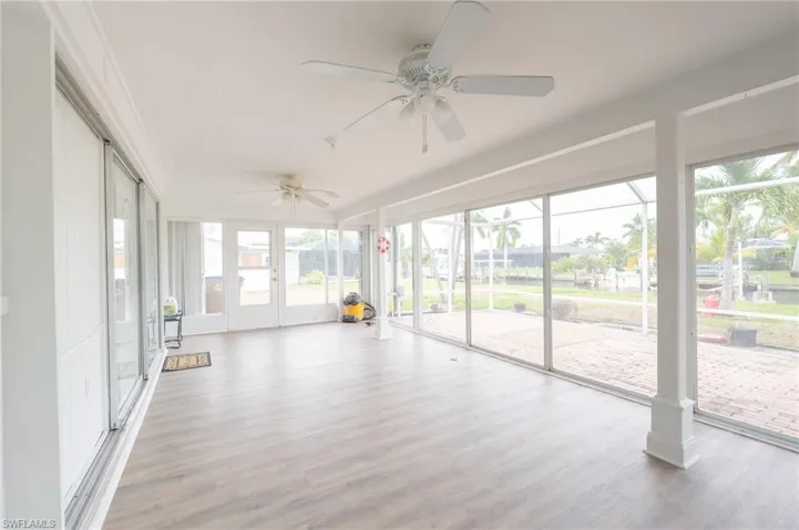 Unfurnished sunroom with french doors and ceiling fan