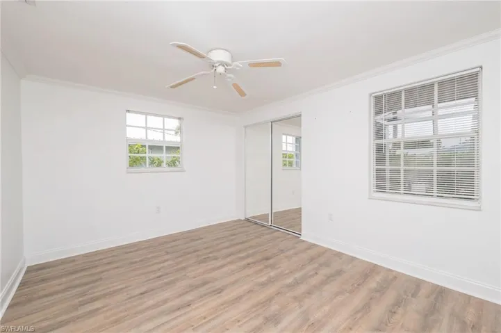 Unfurnished room featuring ceiling fan, hardwood / wood-style floors, and ornamental molding