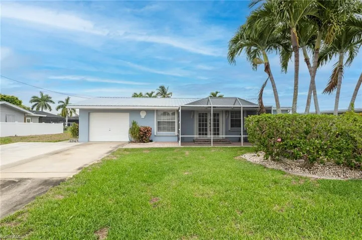 Ranch-style home with a garage and a front lawn