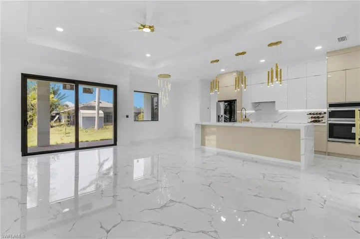 Unfurnished living room featuring recessed lighting, a tray ceiling, and ceiling fan