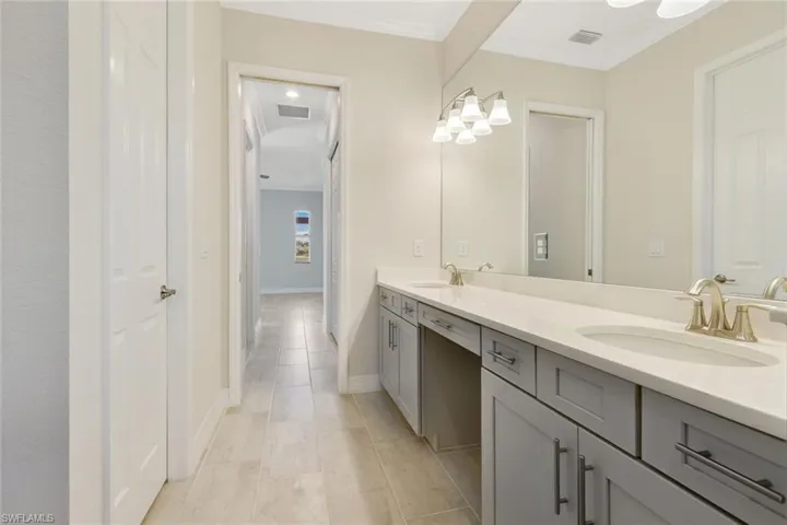 Primary bath with double sink, oversized vanity, expansive mirror.