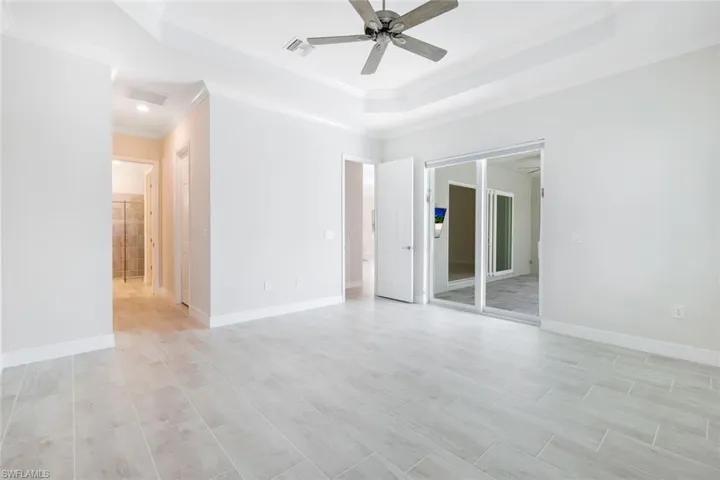 Primary bedroom with sliding impact glass doors to the pool area.