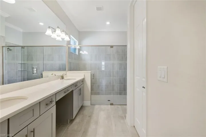 Primary Bathroom featuring double sink and walk in shower