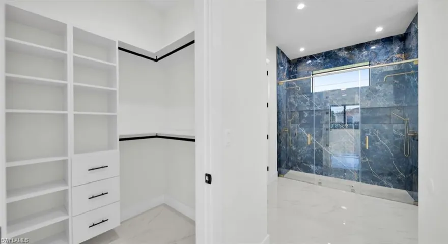 Full bath with light marble finish flooring, a marble finish shower, recessed lighting, and a closet