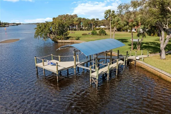 View of dock with a water view and a lawn