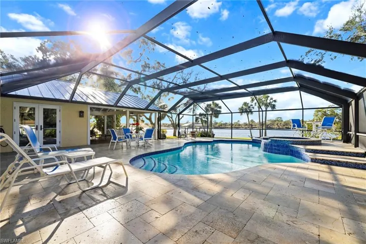 View of swimming pool with an in ground hot tub, a lanai, and a patio area