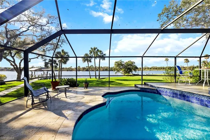View of pool with a water view, a patio, a lanai, and a lawn