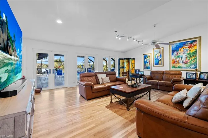 Living room featuring french doors, lofted ceiling, and light wood-type flooring