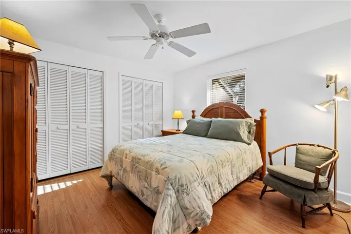 Bedroom featuring ceiling fan, hardwood / wood-style floors, and two closets