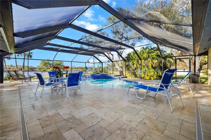 View of pool featuring glass enclosure and a patio area