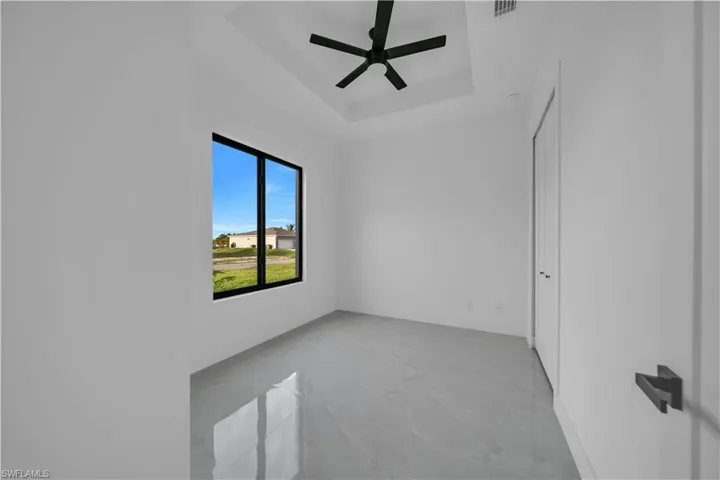 Empty room with a raised ceiling and ceiling fan
