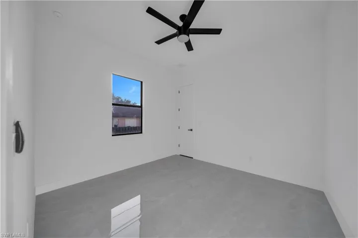 Empty room featuring ceiling fan and baseboards
