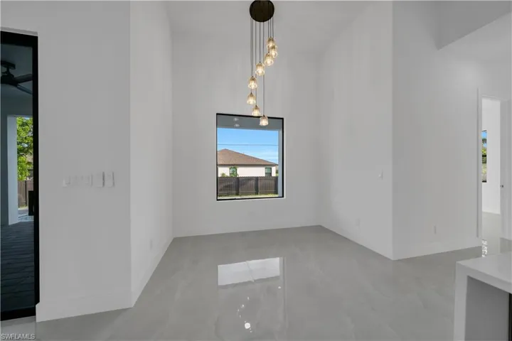 Unfurnished room featuring plenty of natural light and baseboards