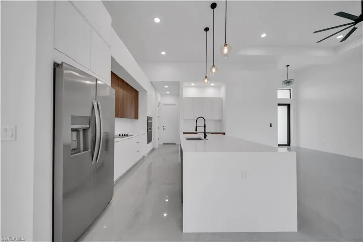 Kitchen featuring appliances with stainless steel finishes, modern cabinets, a sink, white cabinetry, and recessed lighting