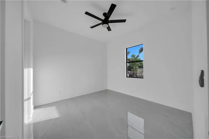 Unfurnished room with ceiling fan, baseboards, and finished concrete floors