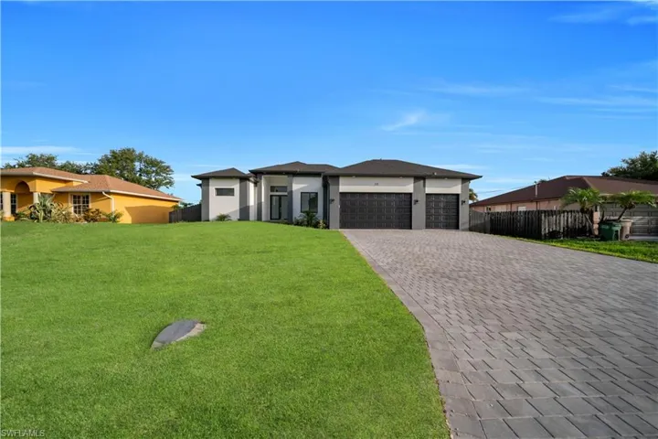 Prairie-style home with an attached garage, decorative driveway, and stucco siding