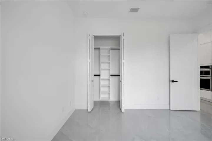 Unfurnished bedroom with baseboards and marble finish flooring