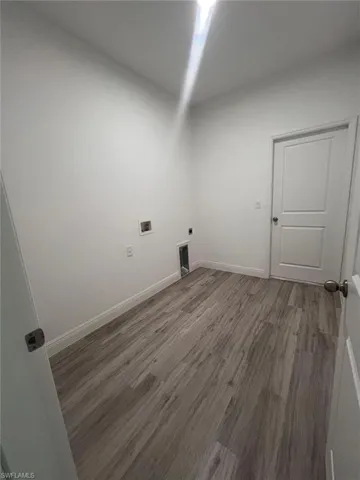 Laundry area with hookup for a washing machine, hardwood / wood-style floors, and electric dryer hookup