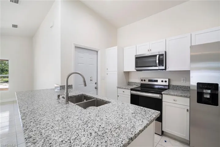 Kitchen featuring an island with sink, stainless steel appliances, and sink