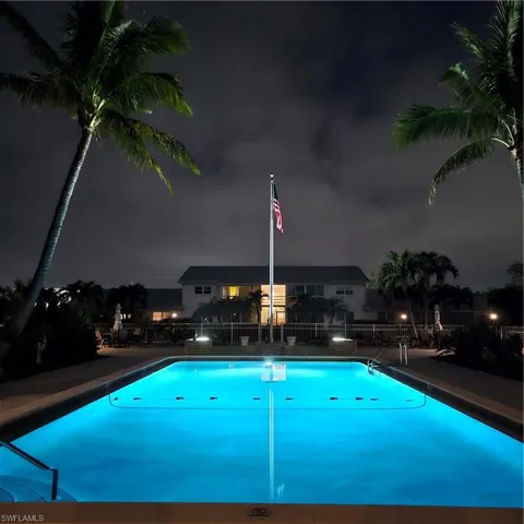 Night time view over the pool. D6 is the upper LH Condo (light is on) in the building beyond the flag pole
