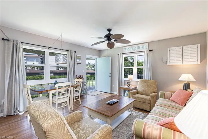 Living room with ceiling fan and hardwood / wood-style flooring