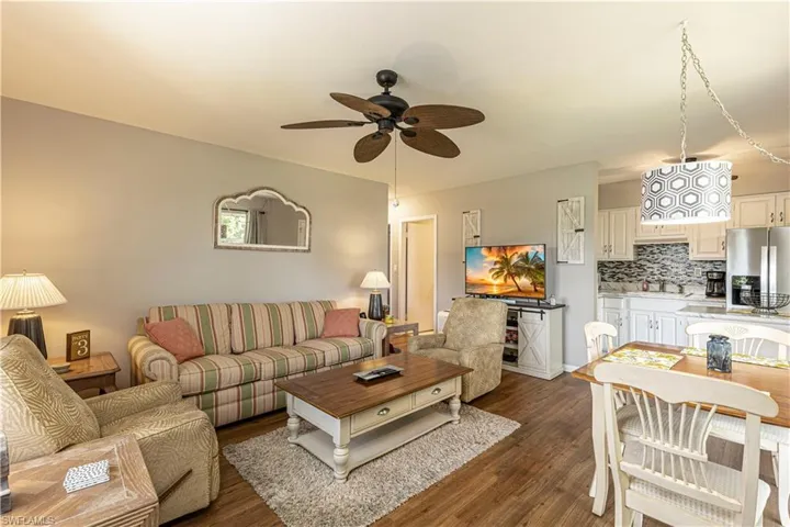 Living room featuring dark hardwood / wood-style floors, ceiling fan, and sink