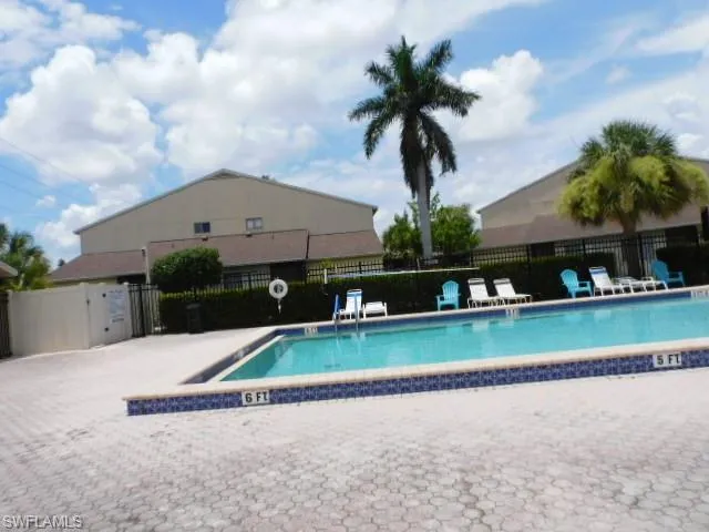 Outdoor swimming pool featuring a tiled edge and a paver deck