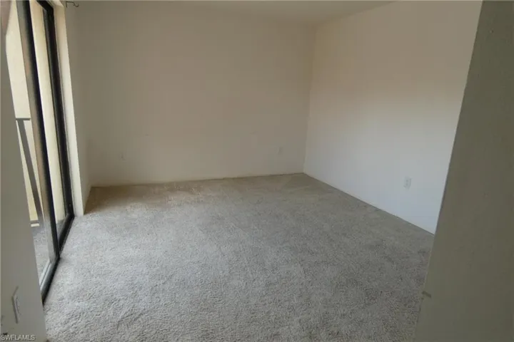 Bright room featuring neutral wall finishes and light-toned carpeting