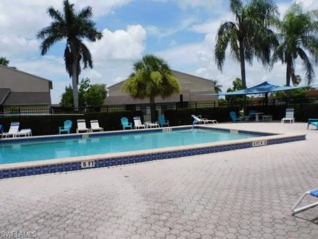 Rectangular swimming pool featuring blue mosaic tiling and a neutral-toned paver surround
