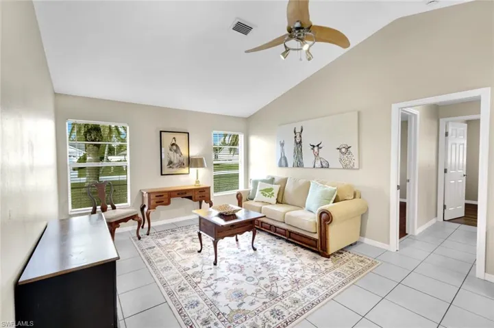 Tiled living room with high vaulted ceiling and ceiling fan