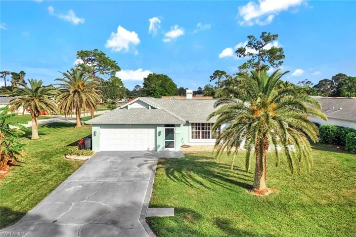 View of front of home with a garage and a front yard