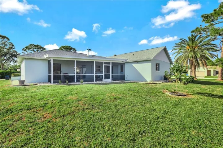 Rear view of property featuring a yard and a sunroom