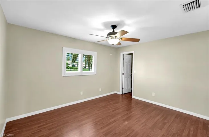 Empty room featuring dark hardwood / wood-style floors and ceiling fan
