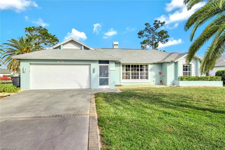 Single story home featuring a garage and a front yard