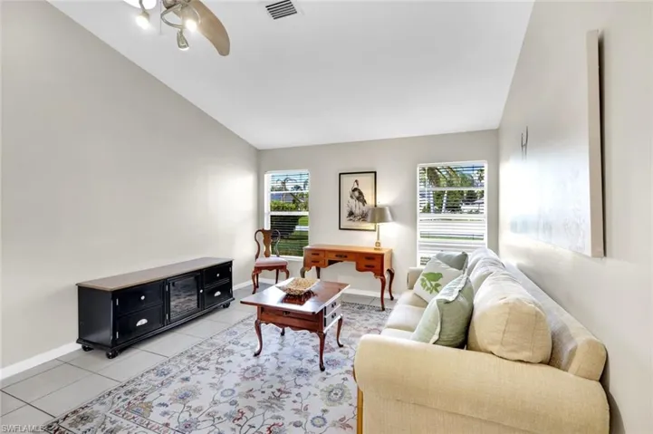 Tiled living room featuring ceiling fan and lofted ceiling