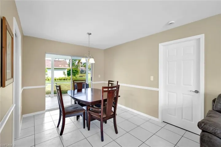 Dining room with a notable chandelier and light tile patterned floors
