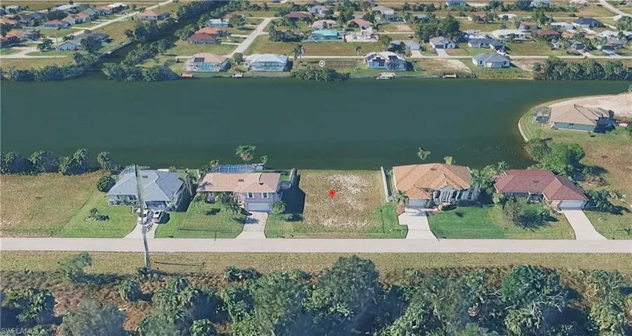 Aerial overview of property's location featuring nearby suburban area and a large body of water