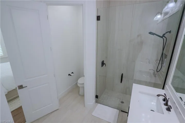 Bathroom with vanity, toilet, and an enclosed shower
