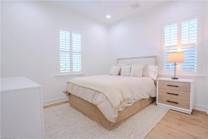 Bedroom with light hardwood / wood-style flooring and multiple windows